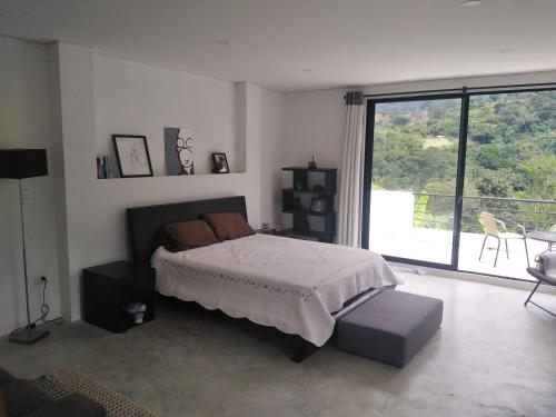 a bedroom with a bed and a large window at Habitación en casa Rural Campestre in La Vega