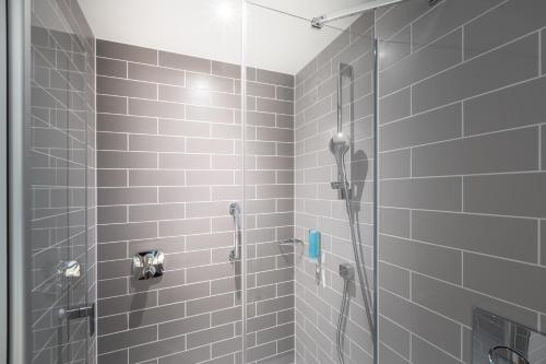 uma casa de banho com um chuveiro e uma porta de vidro em Holiday Inn Express - Erlangen, an IHG Hotel em Erlangen