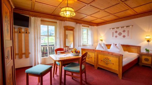 1 dormitorio con 1 cama, mesa y sillas en Berggasthof Lahnerhof, en Liesing