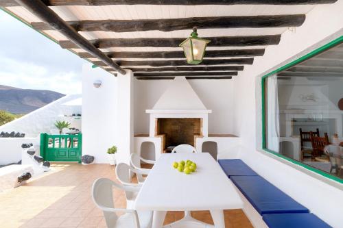 - une salle à manger blanche avec une table et des chaises blanches dans l'établissement Famara Caracolillos, La Casa, à Famara