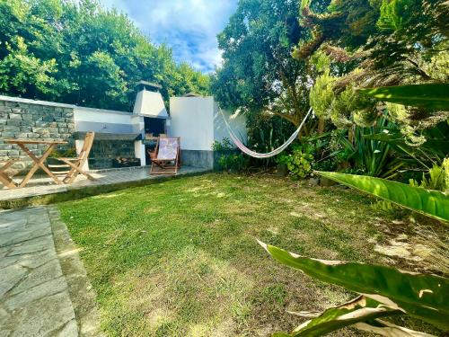 a backyard with a hammock in the grass at Sea Roots "Garden Zone " in Mosteiros