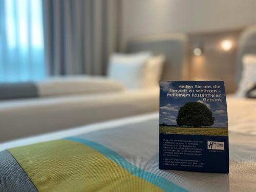 um livro sentado em cima de uma cama em Holiday Inn Express - Erlangen, an IHG Hotel em Erlangen