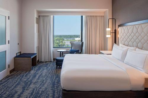 a large white bed in a hotel room with a window at Hilton Shreveport in Shreveport