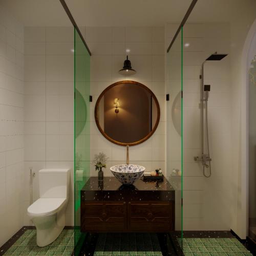 a bathroom with a sink and a toilet and a mirror at La Belle Maison in Hanoi