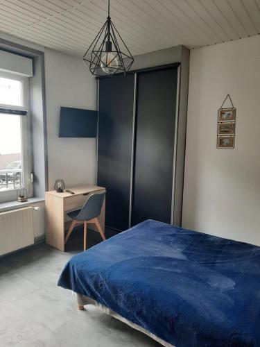 - une chambre avec un lit bleu et un bureau dans l'établissement Studio N°3 Boston Conciergerie Leroy, à Boulogne-sur-Mer