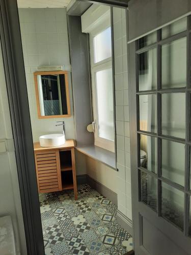une salle de bain avec un lavabo et un miroir dans l'établissement Studio N°3 Boston Conciergerie Leroy, à Boulogne-sur-Mer