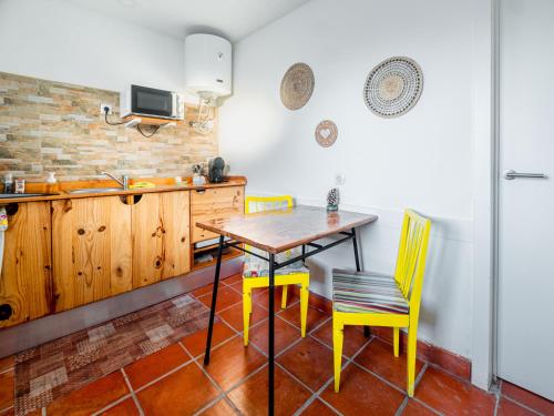a kitchen with a wooden table and yellow chairs at VILA NATURA in Barreiro