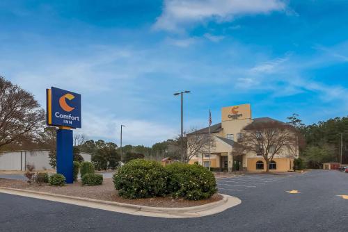a sign for a car dealership in a parking lot at Comfort Inn Fayetteville I-95 in Fayetteville