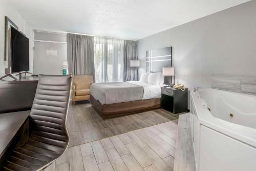 a hotel room with a bed and a bath tub at Quality Inn & Suites Hardeeville - Savannah North in Hardeeville
