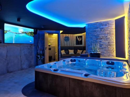 a jacuzzi tub in a living room with a tv at Relax Vila se zahradním wellness in Ostrava