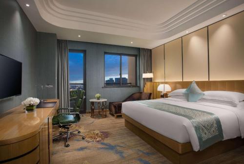 a hotel room with a bed and a desk and a television at Wyndham HangZhou East in Hangzhou