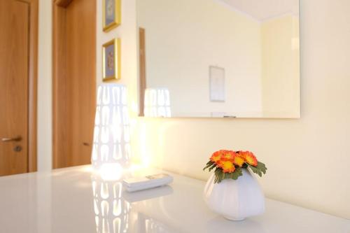 un vase blanc avec des fleurs assis sur une table dans l'établissement Heart of Sorrento Apartment, à Sorrente