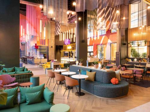 un restaurant avec des canapés, des tables et des chaises dans l'établissement ibis Styles Copenhagen Orestad, à Copenhague