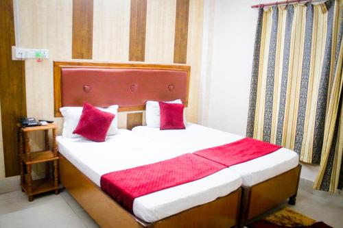 a bedroom with a large bed with red pillows at Hotel Pahuna Ghar in Nepālganj