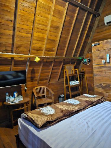 ein Schlafzimmer mit Bett, Schreibtisch und Fernseher in der Unterkunft Luxury Wooden House in Kebumen