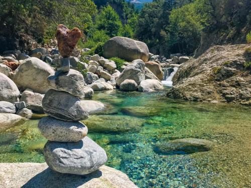 a pile of rocks sitting on top of a river at chambre d'hôte cosy L'AGHJA in Carbuccia