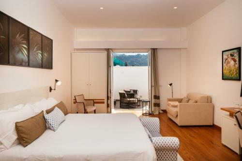 a bedroom with a bed and a living room at Villa Fiorella Art Hotel in Massa Lubrense