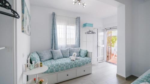 sala de estar con sofá azul y ventana en Villa Franca Competa by Ruralidays, en Cómpeta