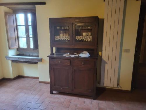 um grande armário de madeira num quarto com uma janela em bacciano casa vacanze em Poggio