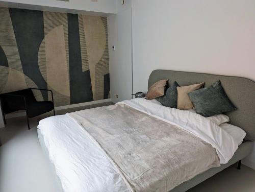 a bedroom with a bed and a painting on the wall at Spacious and cosy apartment near Berchem Station in Antwerp