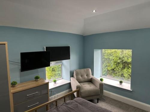 a living room with a chair and a television at Luxurious 2 Bedroom Private Detached Cottage in Llanddulas