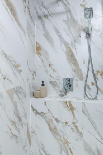 a shower in a bathroom with marble walls at Шаян Гора in Shaian