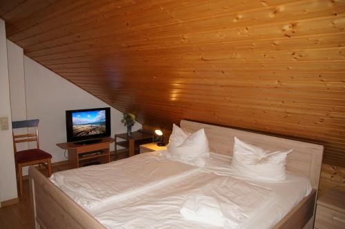 een slaapkamer met een wit bed en een houten plafond bij Urlauberdorf Urlauberdorf 49d in Boltenhagen