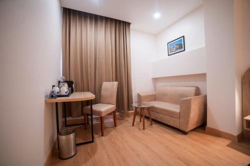 a room with a table and a couch and a chair at Zip By Spree Hotels Gangtok in Gangtok