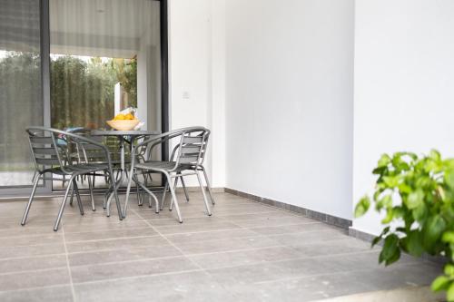 a table and chairs sitting on a porch at Pagani Green - Luxury Maisonette I2 in Kalamata