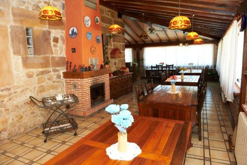 un restaurante con mesas de madera y chimenea en Posada La Capía, en Vargas
