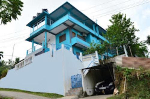 niebieski dom z samochodem przed nim w obiekcie Pramod Bhawan , Port Blair w mieście Port Blair