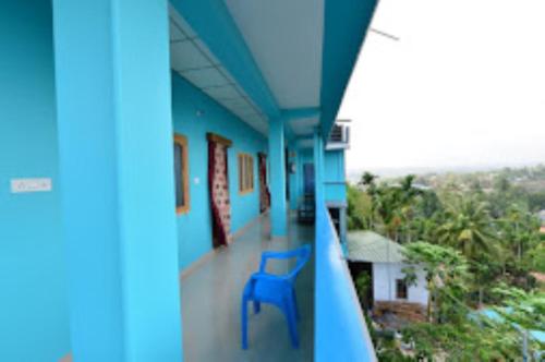 a blue chair sitting on the balcony of a house at Pramod Bhawan , Port Blair in Port Blair