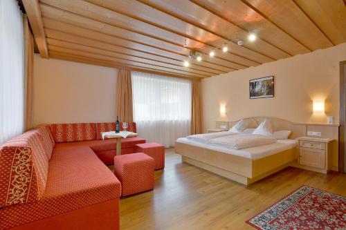 1 dormitorio con 1 cama y 1 sofá en Scheulinghof, en Mayrhofen