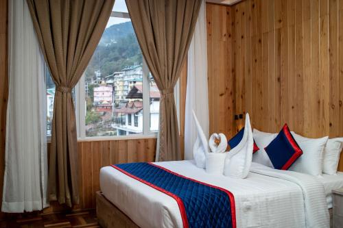 a bedroom with a large bed with a window at Zip By Spree Hotels Gangtok in Gangtok