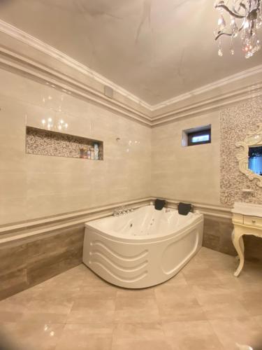 un ampio bagno con una grande vasca in una stanza di Baku Villa Family a Baku
