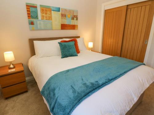 sypialnia z łóżkiem z niebieskim kocem w obiekcie Causeway Hideaway w Sheffield