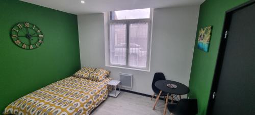 une chambre avec un lit et une horloge au mur dans l'établissement Studio Hibiscus tout confort, rénové, à Saint-Quentin