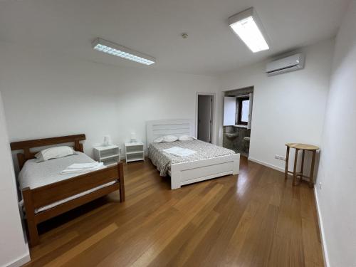 a bedroom with two beds and a wooden floor at Casa em Aldeia rural - Circuito Aldeias de Portugal in Ponte de Lima