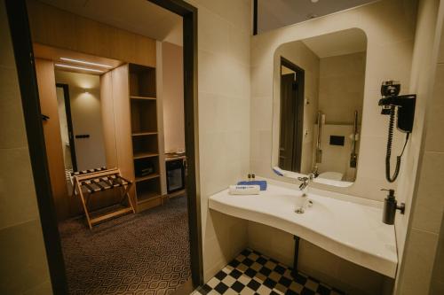 a bathroom with a sink and a mirror at Coop Hotell in Jõgeva