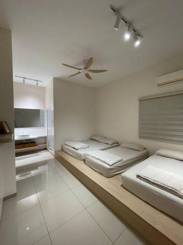 2 camas num quarto branco com uma ventoinha de tecto em Lam Lee Durian Farm em Yong Peng