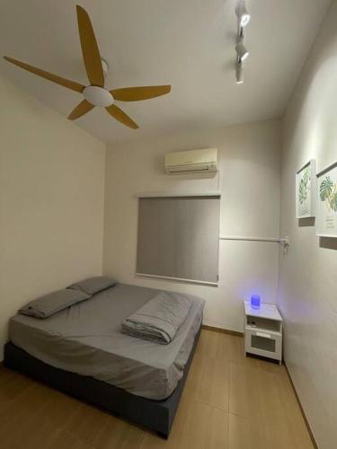 - une chambre avec un lit et un ventilateur de plafond dans l'établissement Lam Lee Durian Farm, à Yong Peng