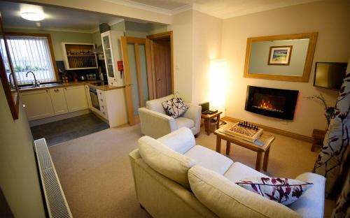 a living room with a couch and a fireplace at Kiltaraglen House in Portree