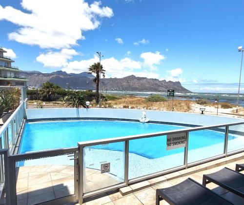 a swimming pool with a view of the ocean at Tranquil Impulse on Strand in Cape Town
