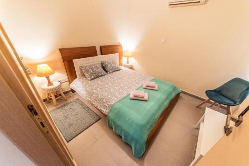 a small bedroom with a bed and a blue chair at 3 bed, Kapparis, Thea - 3A in Paralimni