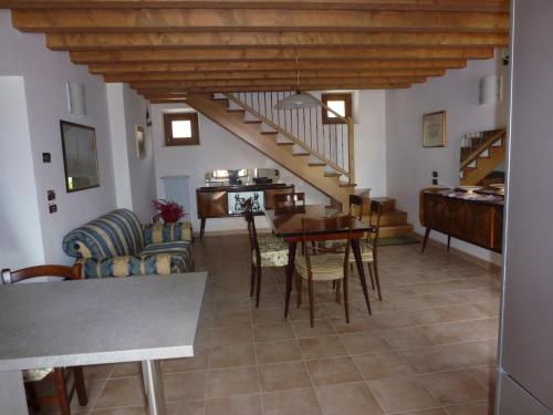 a living room with a staircase and a table and chairs at Casa Del Nonno in Tarzo