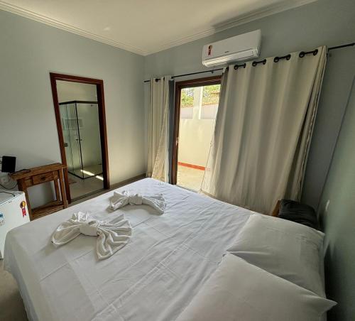 um quarto com uma cama branca e um espelho em Pousada Ribeirinha em São José da Barra