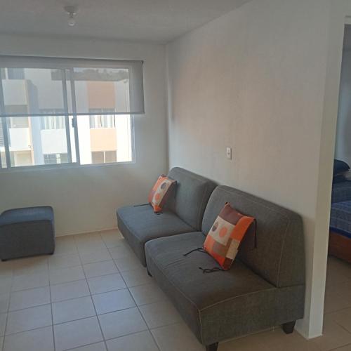 a living room with a couch and a window at Depto cerca de Tequesquitengo in Tlatenchu