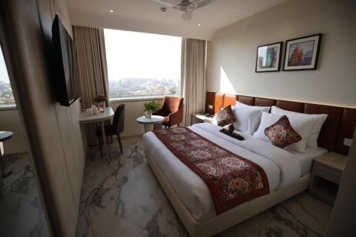 Habitación de hotel con cama grande y ventana en Hiraya Hotels en Mohali