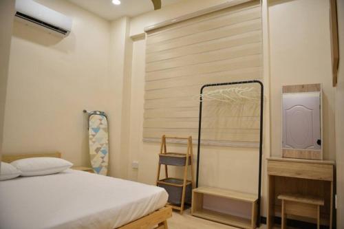 - une chambre avec un lit et un mur en bois dans l'établissement Your home away from home., à Sandakan