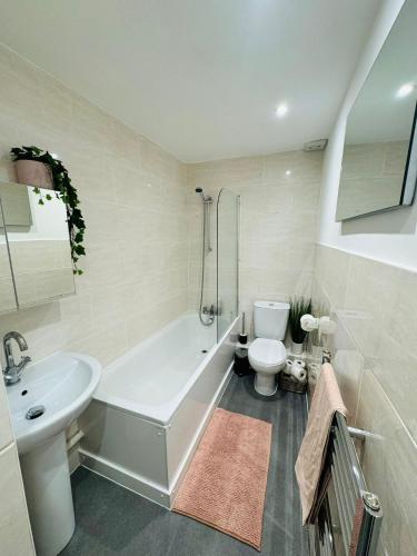 y baño con bañera, aseo y lavamanos. en Jubilee Rooms 15 Minutes Central London en Londres